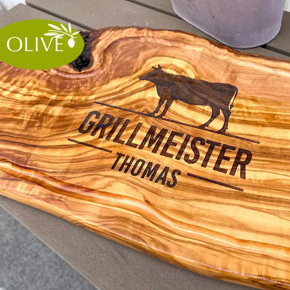 Motiv GRILLMEISTER mit Wusnchnamen und stilisiertem Rind - Mediterranes Schneidebrett aus Olivenholz mit Saftrille und personalisierten Gravurmotiv - Jeske Design