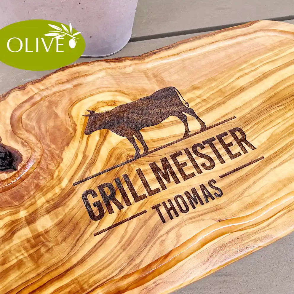Motiv GRILLMEISTER mit Wusnchnamen und stilisiertem Rind - Mediterranes Schneidebrett aus Olivenholz mit Saftrille und personalisierten Gravurmotiv - Jeske Design