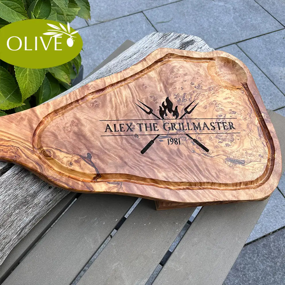 Motiv THE GRILLMASTER - Mediterranes Schneidebrett aus Olivenholz mit Handgriff und Saftrille und personalisierten Gravurmotiv - Jeske Design