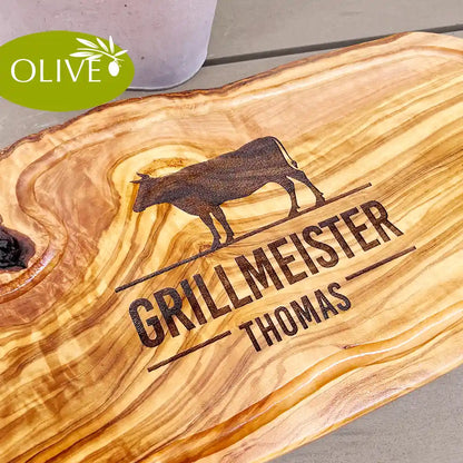 Motiv GRILLMEISTER mit Wusnchnamen und stilisiertem Rind - Mediterranes Schneidebrett aus Olivenholz mit Saftrille und personalisierten Gravurmotiv - Jeske Design