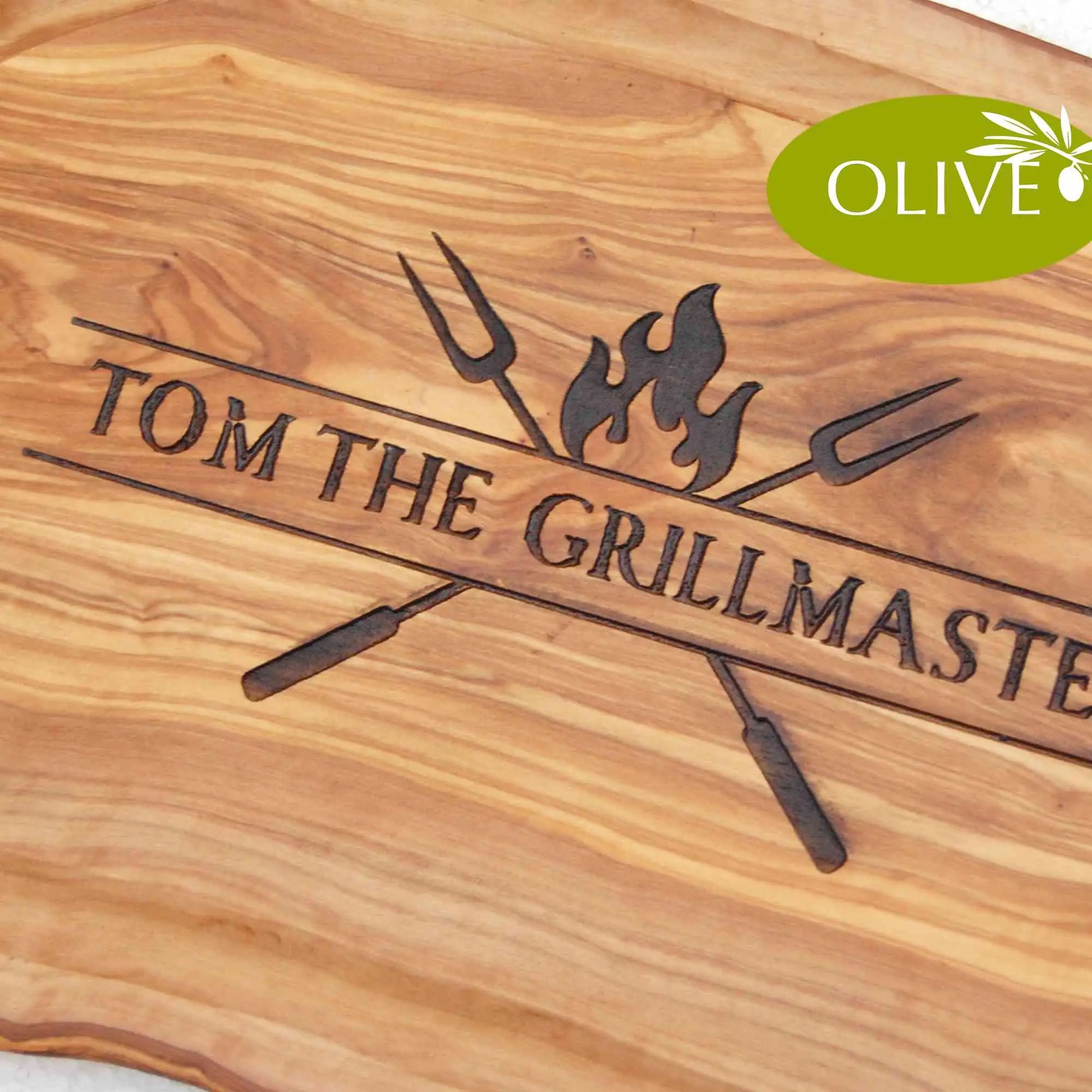 Mediterranes Schneide- und Tranchierbrett aus Olivenholz mit personalisiertem BBQ-Motiv THE GRILLMASTER mit gekreuzten Grillgabeln und Wunschname eingraviert