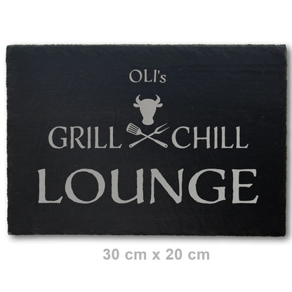 Deko Schieferplatte in der Größe 30 x 20 cm mit dem Motiv Grill und Chill Lounge, das auf die Schieferplatte in personalisierter Form mittels Laser graviert wird. Zwischen Grill und Chill sind gekreuzte Grillgabeln und ein stilisierter Bullenkopf.