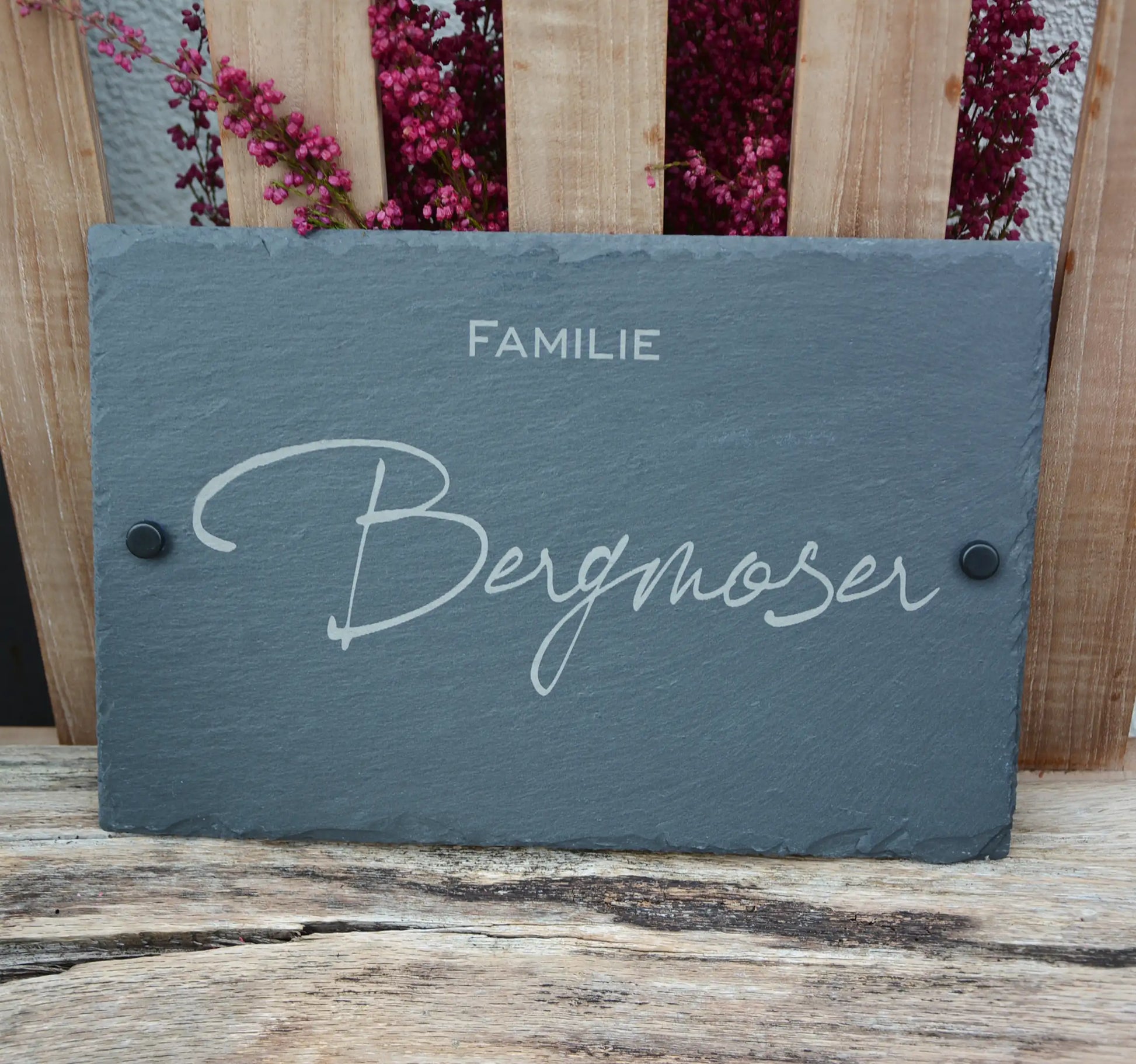 Tür- und Namensschild aus Schiefer mit schwungvoller Handschrift in personalisierter Form in der Größe 30 x 20 cm. Hier als Beispiel "Familie" in kleinerer Zeile unterhalb des Nachnamens und schwarzen Abstandshalter